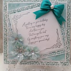 Luxury Handmade Birthday - Aquamarine, White & Silver Birthday sentiment card with spray of vellum flowers and peacock green bow