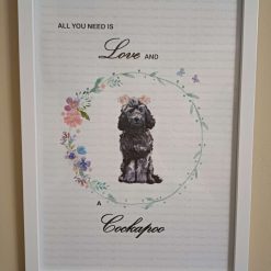 Cockapoo Print, Dog Wall Art, Black Cockapoo wearing two clusters of pink flowers in her hair standing in a circle of flowers, Home Decor, Dog Lover Framed Print