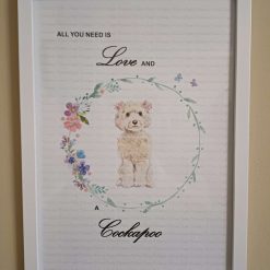 Cockapoo Print, Dog Wall Art, White/Cream/Champagne Cockapoo wearing two clusters of pink flowers in her hair standing in a circle of flowers, Home Decor, Dog Lover Framed Print