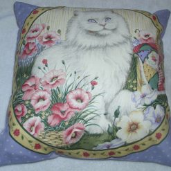 A lovely white cat with violet eyes in a garden of flowers cushion pillow