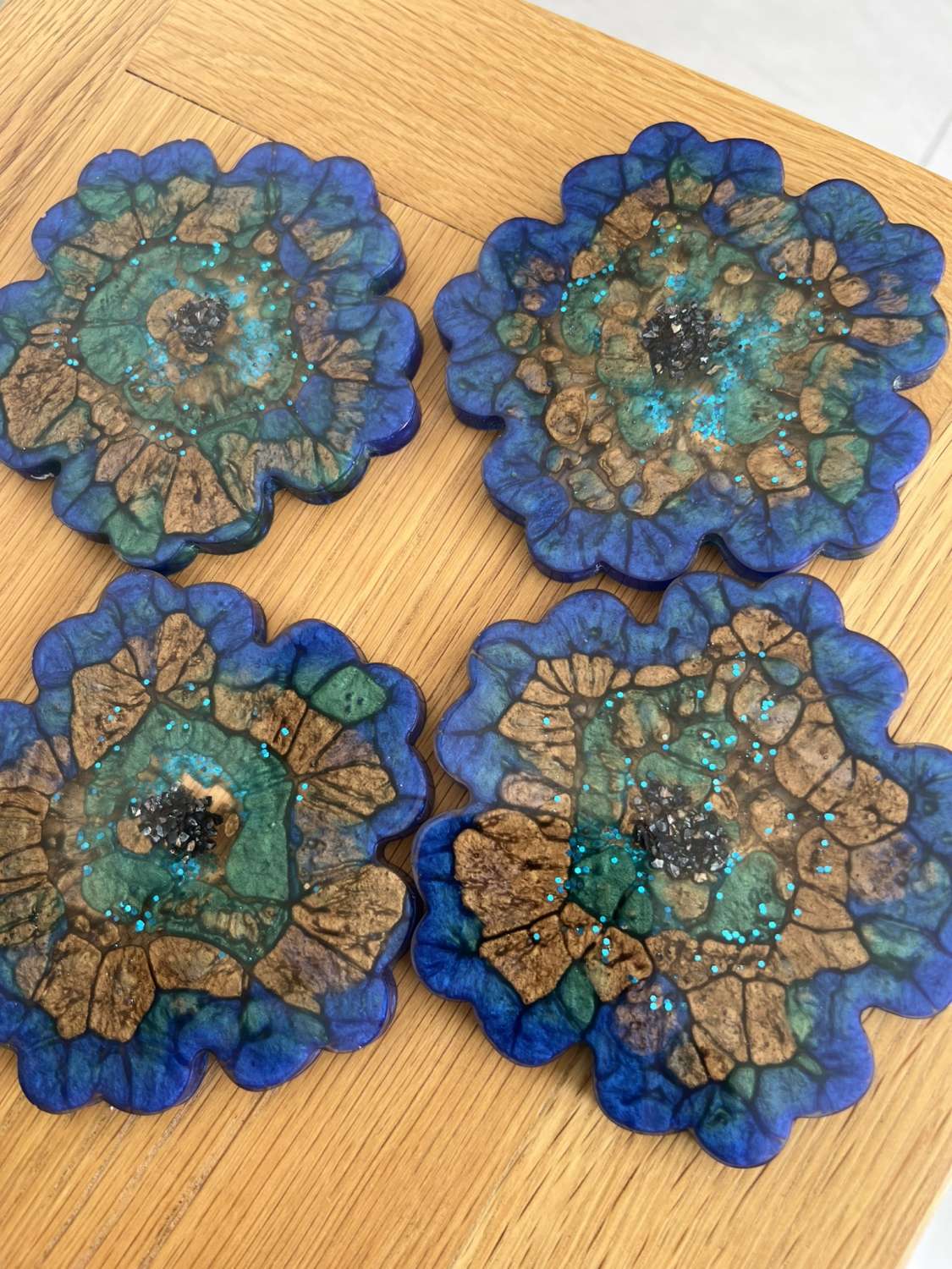 4 resin coasters created through a mix of mica powders and resin MadeMe