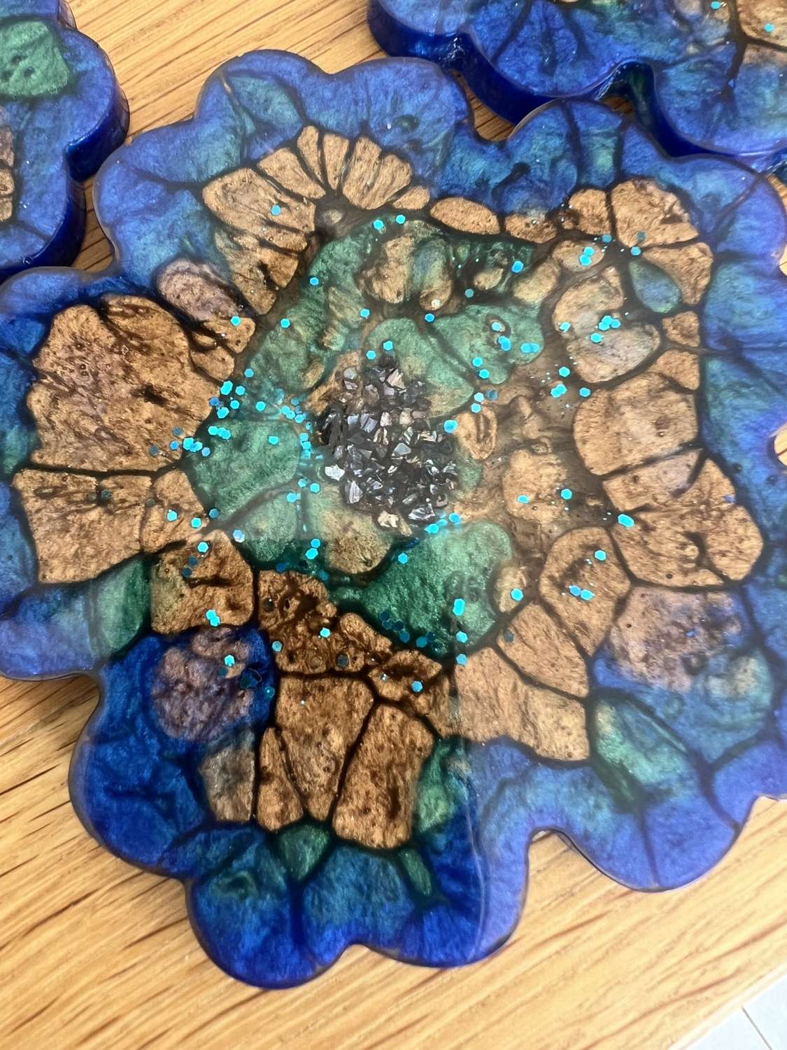 4 resin coasters created through a mix of mica powders and resin MadeMe