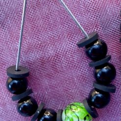 Black beads with, black spacer beads and a white glass bead in the centre