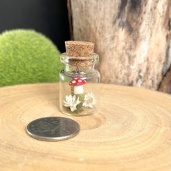 Miniature handmade ceramic toadstool dangling in a sweet glass jar 4