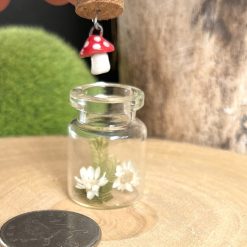 Miniature handmade ceramic toadstool dangling in a sweet glass jar 3