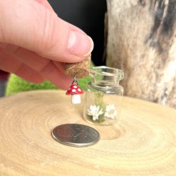 Miniature handmade ceramic toadstool dangling in a sweet glass jar 2