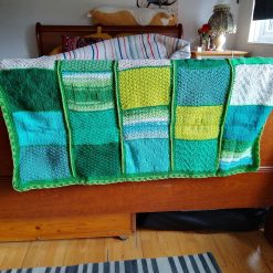 Hand knitted baby blanket in green colourway